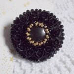 Bague Cléopâtra brodée avec une pierre de gemme : l'onyx Noir avec des cabochons ronds en forme de roses Noires, des rocailles Dorées et des perles rondes facettées aplaties sur une bague filigranée 